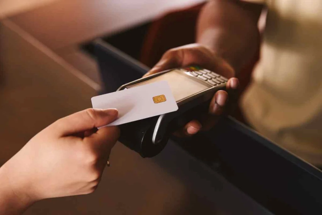 Customer making contactless payment on POS device at small business in Nigeria